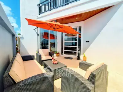 Charming outdoor patio with modern furniture and vibrant umbrella, perfect for relaxation and entertaining.