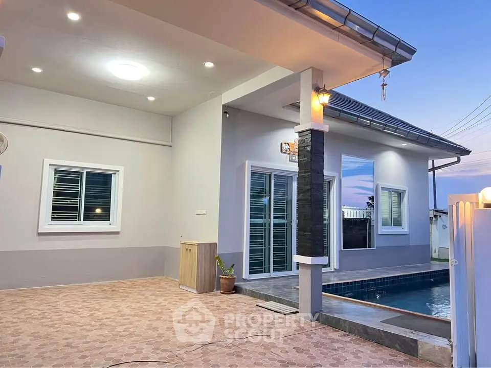 Modern house exterior with pool and stylish lighting at sunset