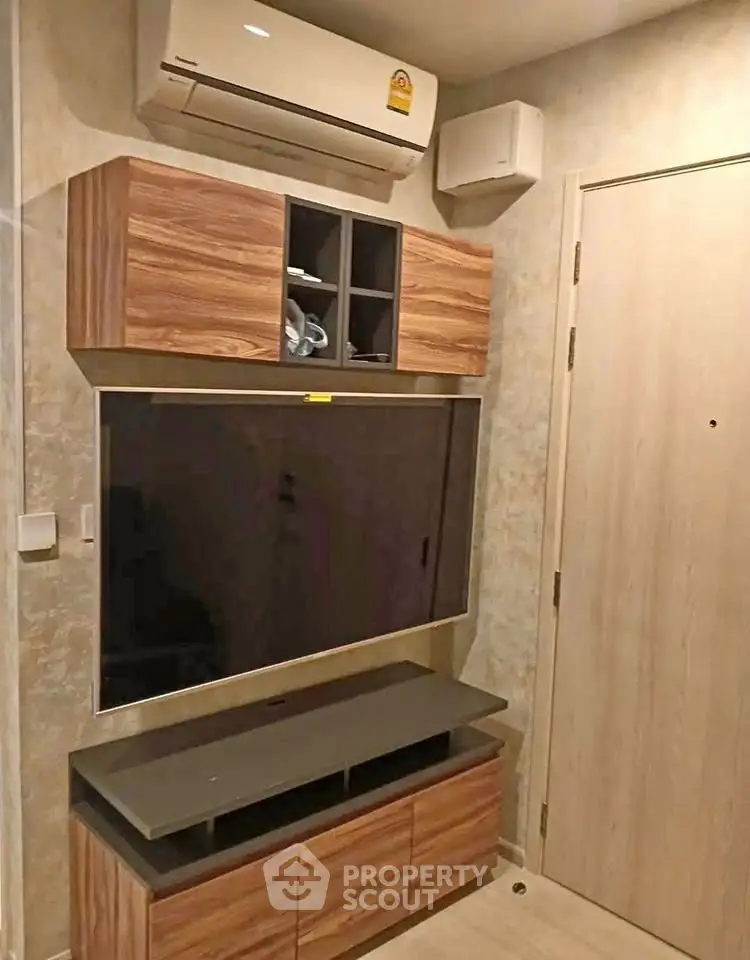 Modern living room with sleek wooden TV cabinet and air conditioning unit.