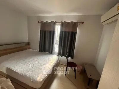Cozy bedroom with natural light, featuring a comfortable bed and modern air conditioning unit.