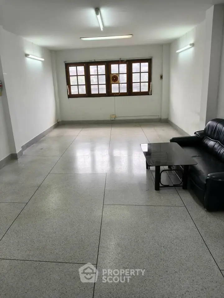 Spacious living room with large windows and minimalist furniture, ideal for customization.