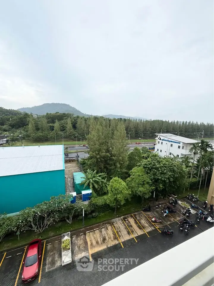 Scenic view from balcony overlooking lush greenery and distant hills, perfect for nature lovers.