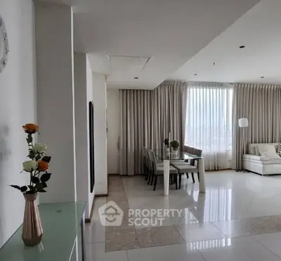 Spacious living room with elegant dining area and large windows