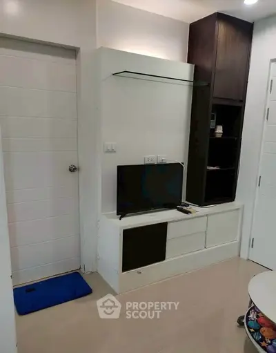 Modern living room with sleek TV unit and glossy tiled floor, perfect for cozy entertainment.