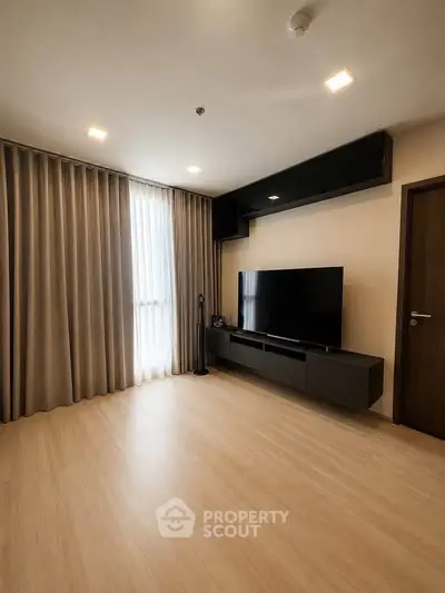 Modern living room with sleek TV unit and floor-to-ceiling curtains