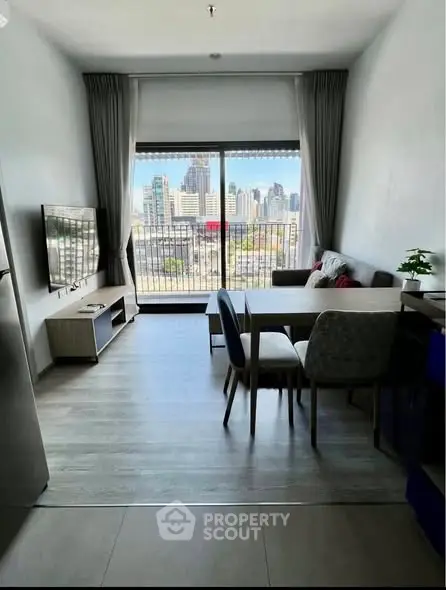 Modern living room with city view, stylish furniture, and large window for natural light.