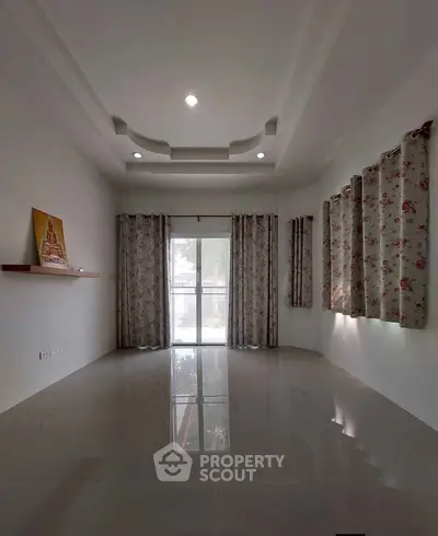 Spacious living room with elegant ceiling design and large windows for natural light.