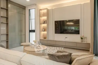 Modern living room with sleek design, built-in shelves, and large TV for ultimate comfort and style.
