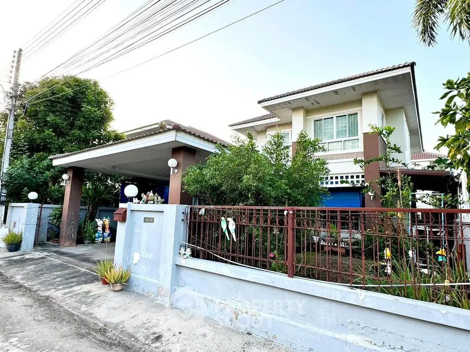 Charming two-story house with lush garden and spacious driveway in a serene neighborhood.