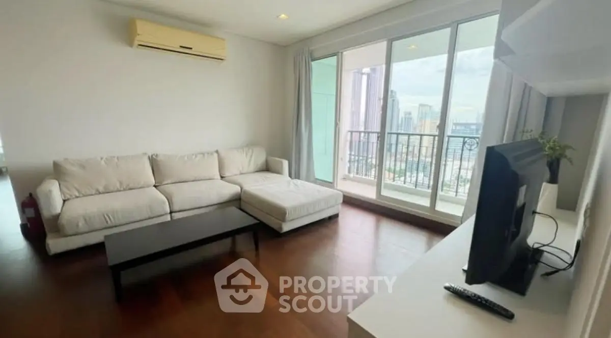 Spacious living room with modern decor and balcony view in high-rise apartment