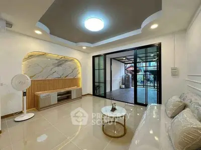 Modern living room with stylish decor and sliding glass doors leading to a spacious balcony.