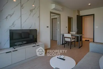 Modern living room with stylish decor and open layout, featuring a sleek TV setup and cozy seating area.