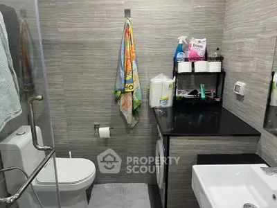 Modern bathroom with sleek design, featuring a washing machine and stylish fixtures.