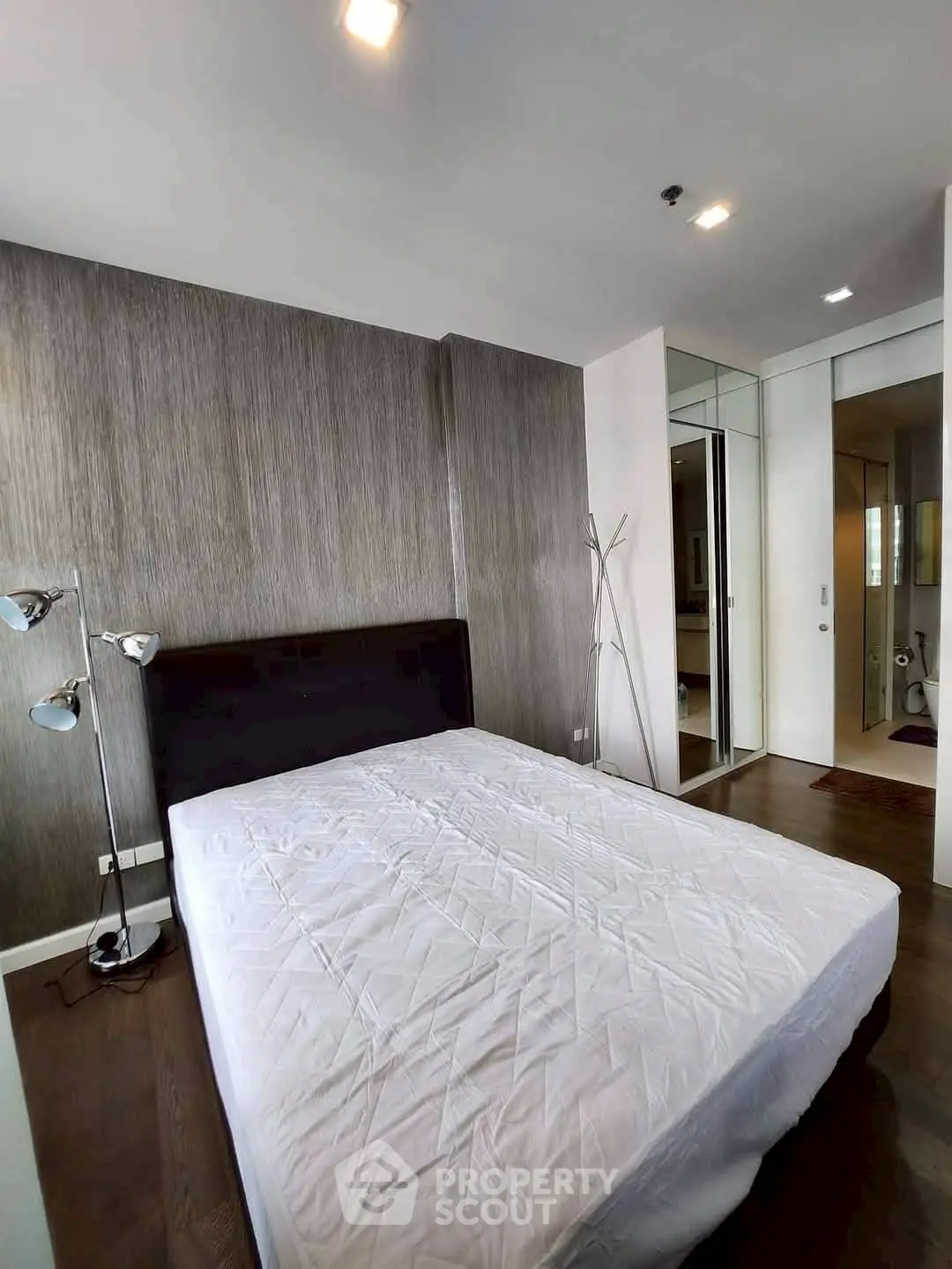 Modern bedroom with stylish decor and hardwood floors in a contemporary apartment.