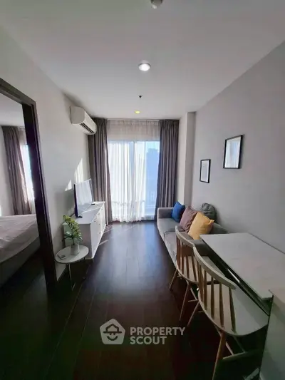 Modern living room with natural light, sleek furniture, and city view.