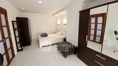 Spacious bedroom with modern furniture and ample storage space.