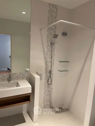 Modern bathroom with sleek shower and stylish sink in contemporary home.