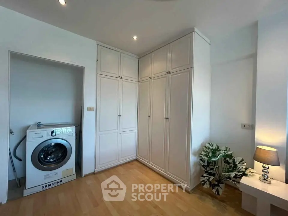 Spacious laundry room with built-in cabinets and washing machine