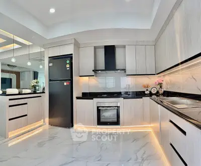 Modern kitchen with sleek cabinetry, marble flooring, and ambient lighting.