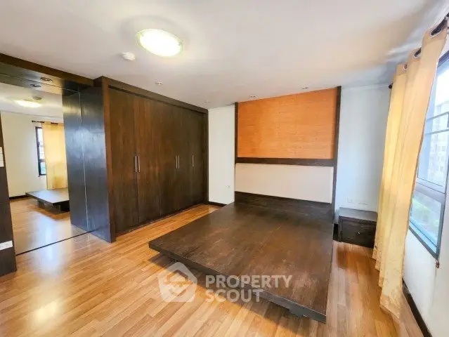 Spacious bedroom with wooden flooring and built-in wardrobe