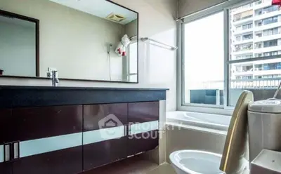 Modern bathroom with large mirror and bathtub in urban apartment