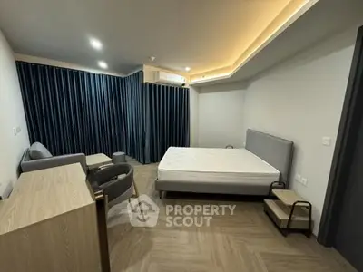 Spacious modern bedroom with elegant furnishings and ambient lighting.