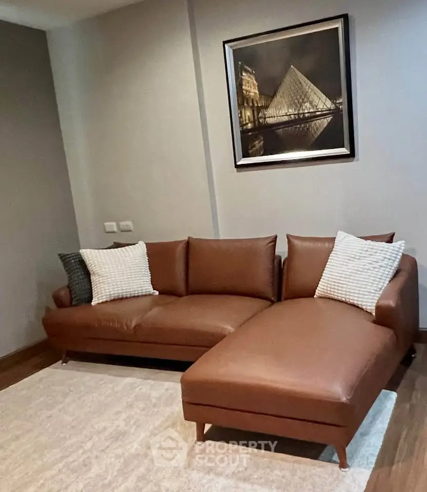 Stylish living room with modern brown leather sectional sofa and elegant wall art.