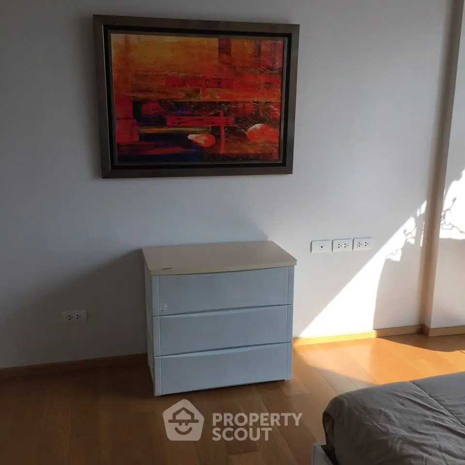 Modern bedroom with stylish art and sleek furniture, showcasing elegant interior design.