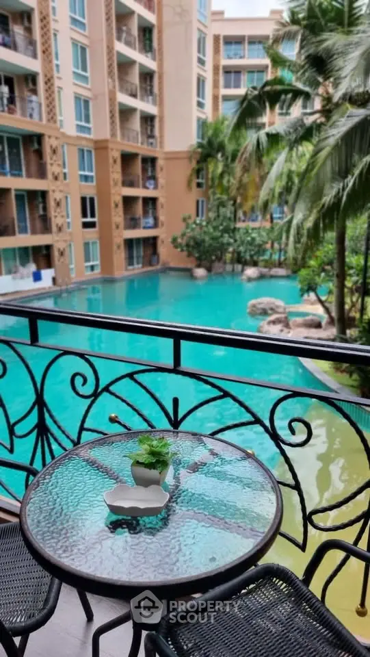 Luxurious balcony view overlooking a stunning pool in a modern apartment complex.