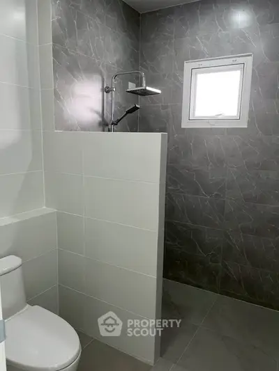 Modern bathroom with sleek gray tiles and a walk-in shower