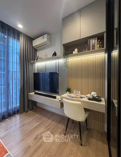 Modern study area with built-in desk, shelves, and TV in a stylish apartment.