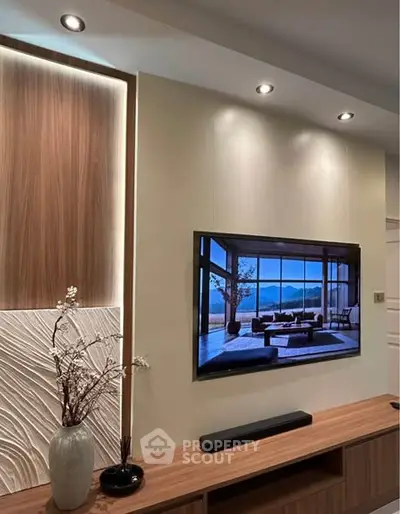 Modern living room with stylish decor and wall-mounted TV showcasing scenic view.