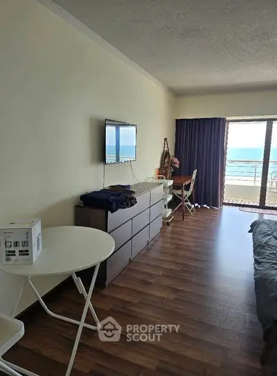Cozy bedroom with ocean view, modern furnishings, and natural light.