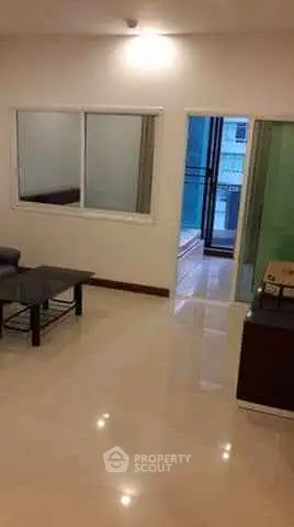Spacious living room with sleek flooring and balcony access