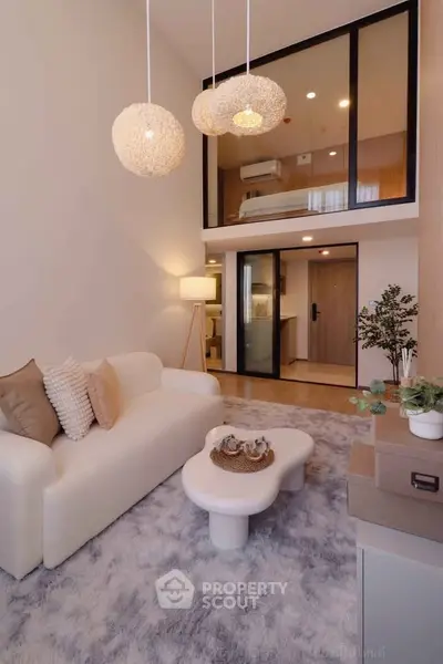 Modern living room with loft bedroom, stylish lighting, and cozy decor in a contemporary apartment.