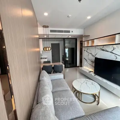 Modern living room with sleek design and marble accents, open layout to kitchen area.