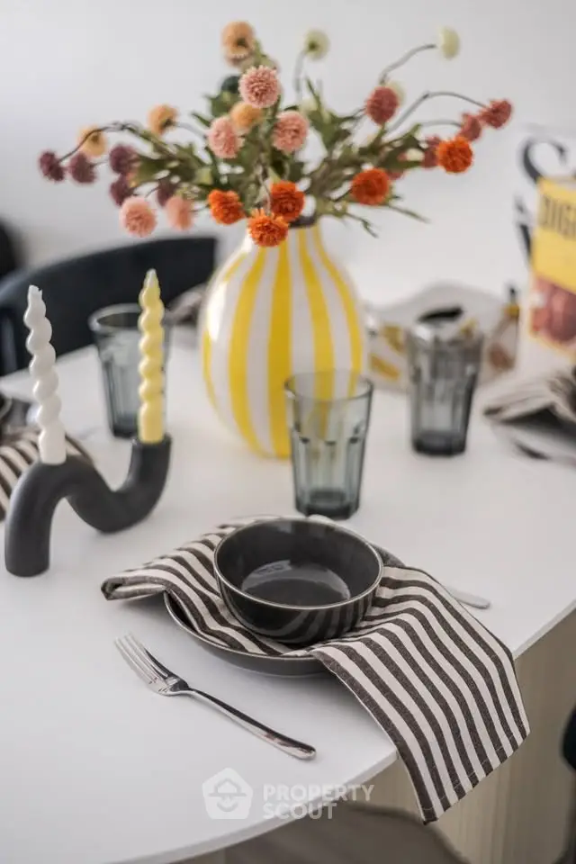 Stylish dining table setup with striped napkins and vibrant floral centerpiece