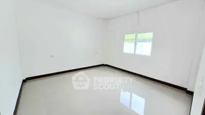 Spacious empty room with glossy tiled floor and bright window view.