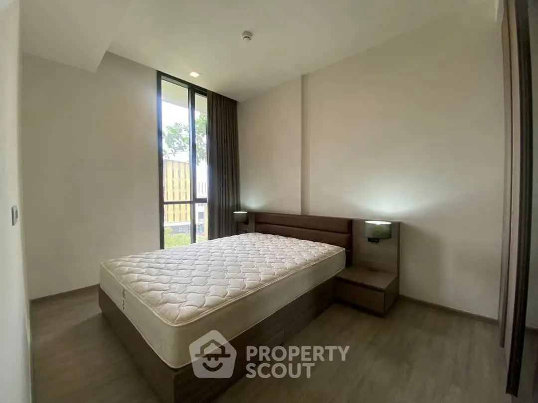 Spacious bedroom with modern design and large window for natural light.