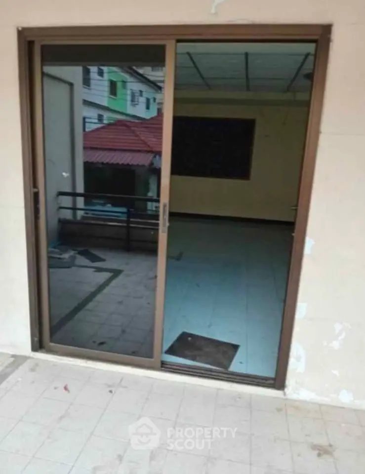 Spacious balcony with sliding glass door and tiled flooring, ideal for outdoor relaxation.