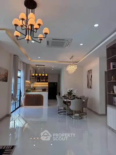 Luxurious open-plan living and dining area with elegant lighting and modern decor.