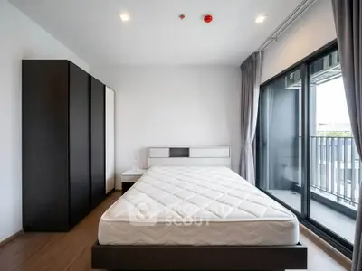 Modern bedroom with large windows and balcony access in a stylish apartment.