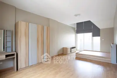 Spacious modern bedroom with wooden flooring and large windows