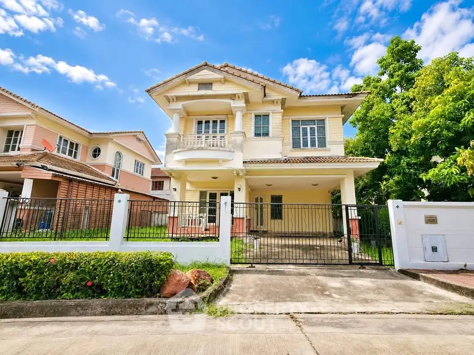 Stunning two-story house with gated entrance and lush greenery, perfect for family living in a serene neighborhood.