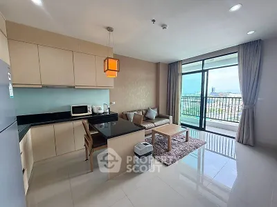 Modern open-layout kitchen and living room with balcony view in a stylish apartment.