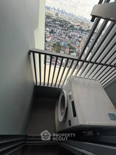 Compact balcony with washing machine and stunning city view from high-rise building.