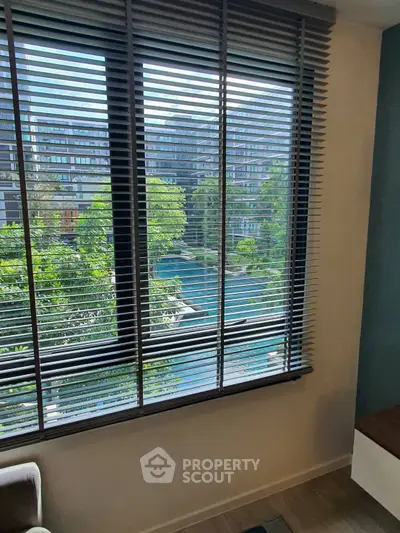 Modern apartment window with cityscape and lush greenery view