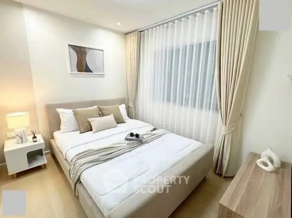 Elegant bedroom with modern decor and natural light, featuring a cozy bed and stylish furnishings.