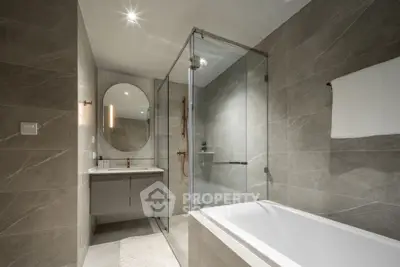 Luxurious modern bathroom with elegant gray tiles and glass shower enclosure.