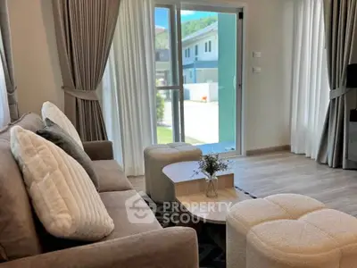 Cozy living room with modern decor and large window offering natural light.